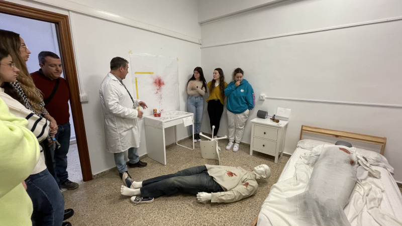 Visita escena del Crimen Varias personas alrededor de un maniquí en el suelo